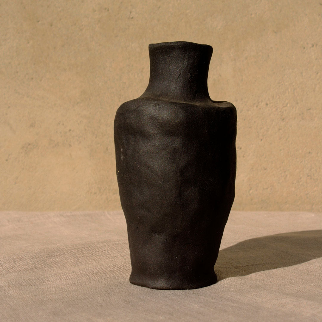 hand made ceramic vessel called Mars by The Adorned in black clay casting a shadow 